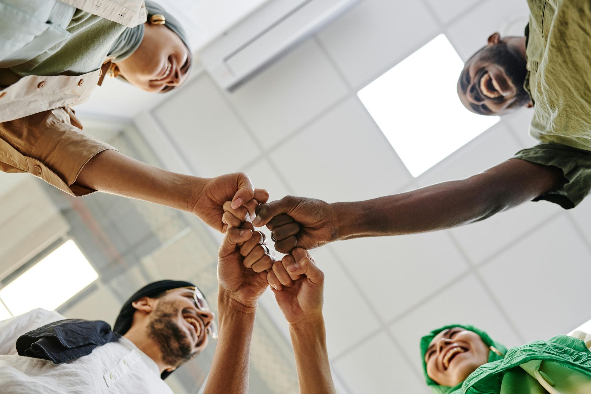 A group of people are putting their hands together in a circle.