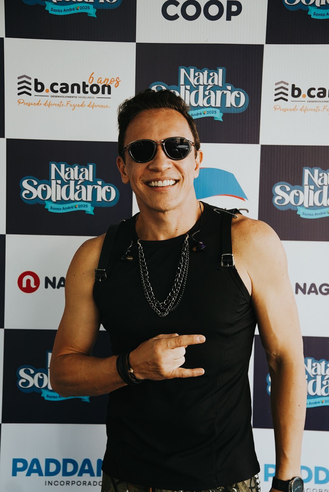 Um artista usando óculos escuros, fazendo gesto de 