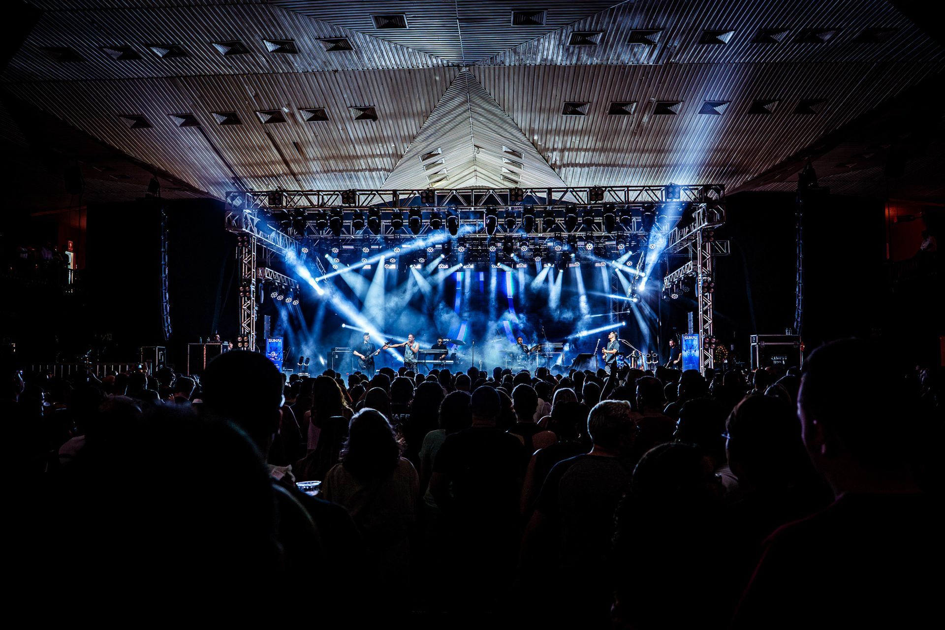 Uma multidão assiste a uma banda se apresentar