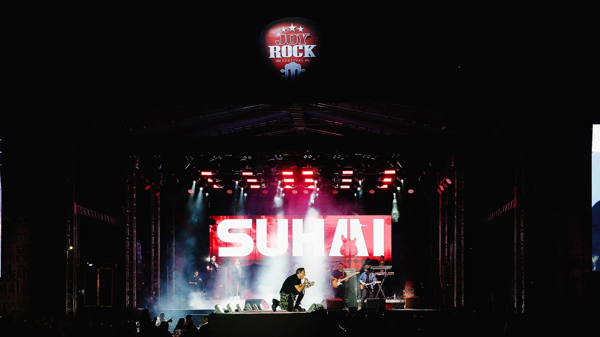 Um palco de concertos à noite exibindo a banda 