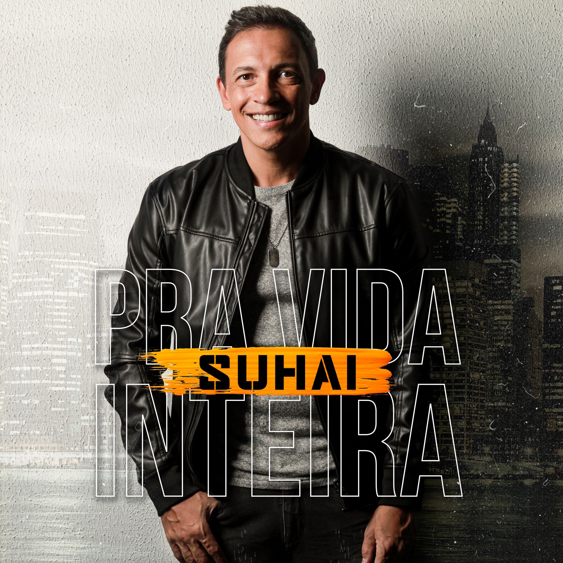 Homem vestindo jaqueta preta sorri em frente a um cenário urbano; a capa do álbum diz 