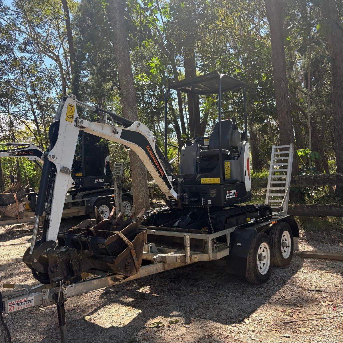 A Small Excavator on a Trailer, Parked Outside on a Sunny Day — Borehams Hire In Meridan Plains, QLD