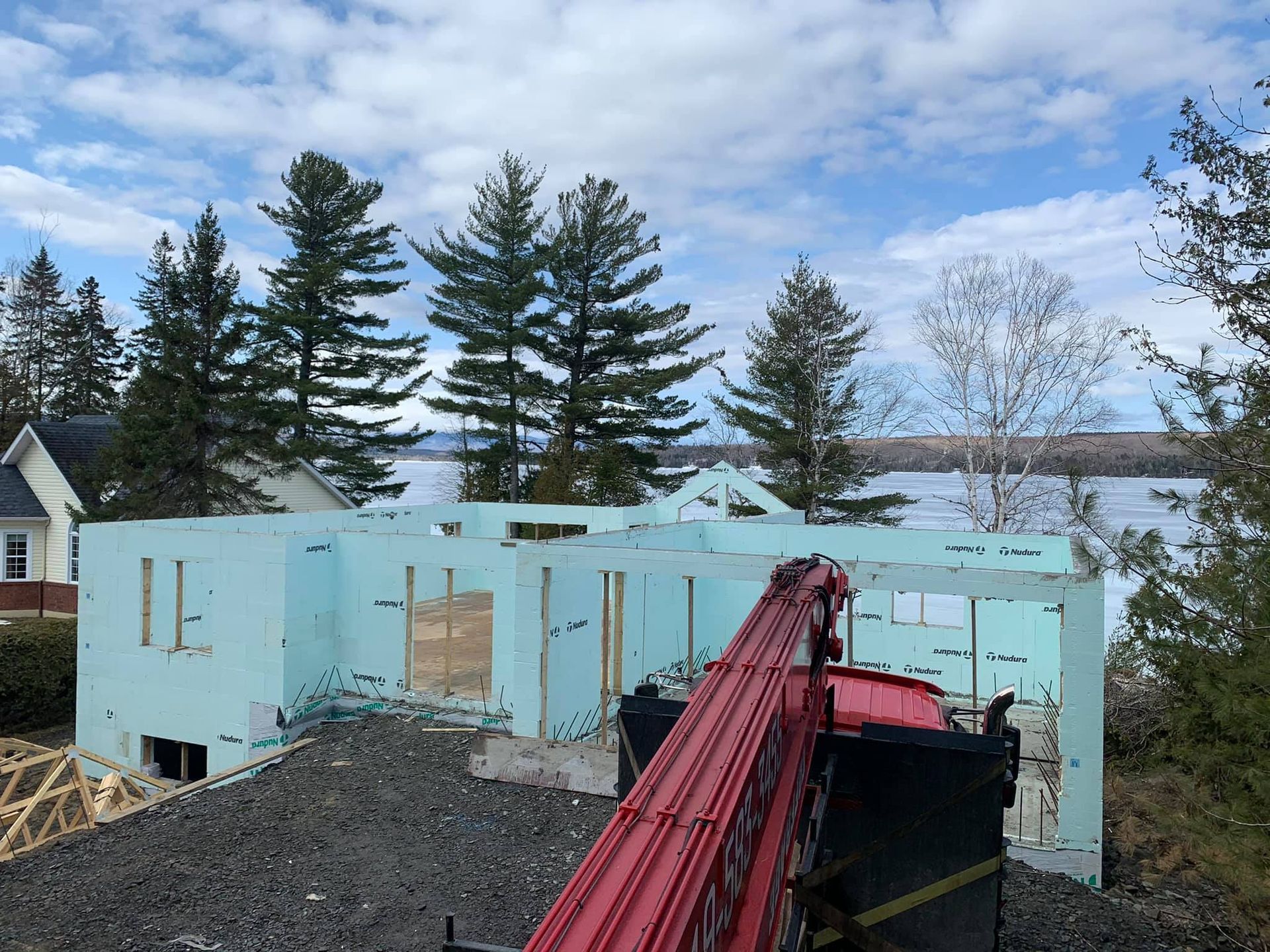 Construire une maison avec des murs en mousse bleue, à côté d'un lac, sous un ciel nuageux.