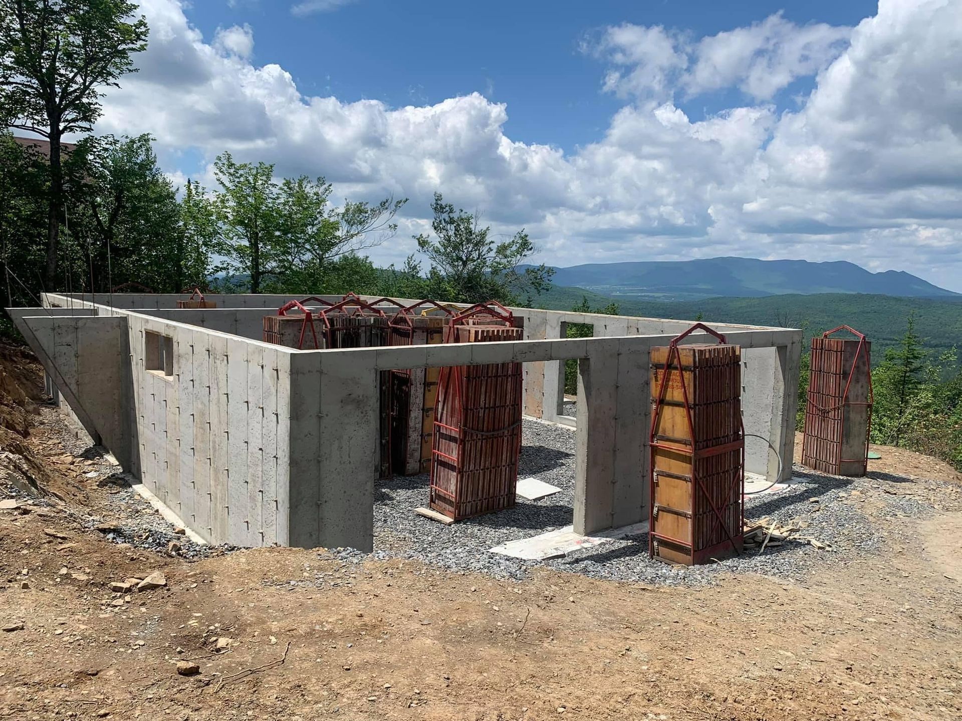Fondation en béton en construction avec vue sur la montagne.