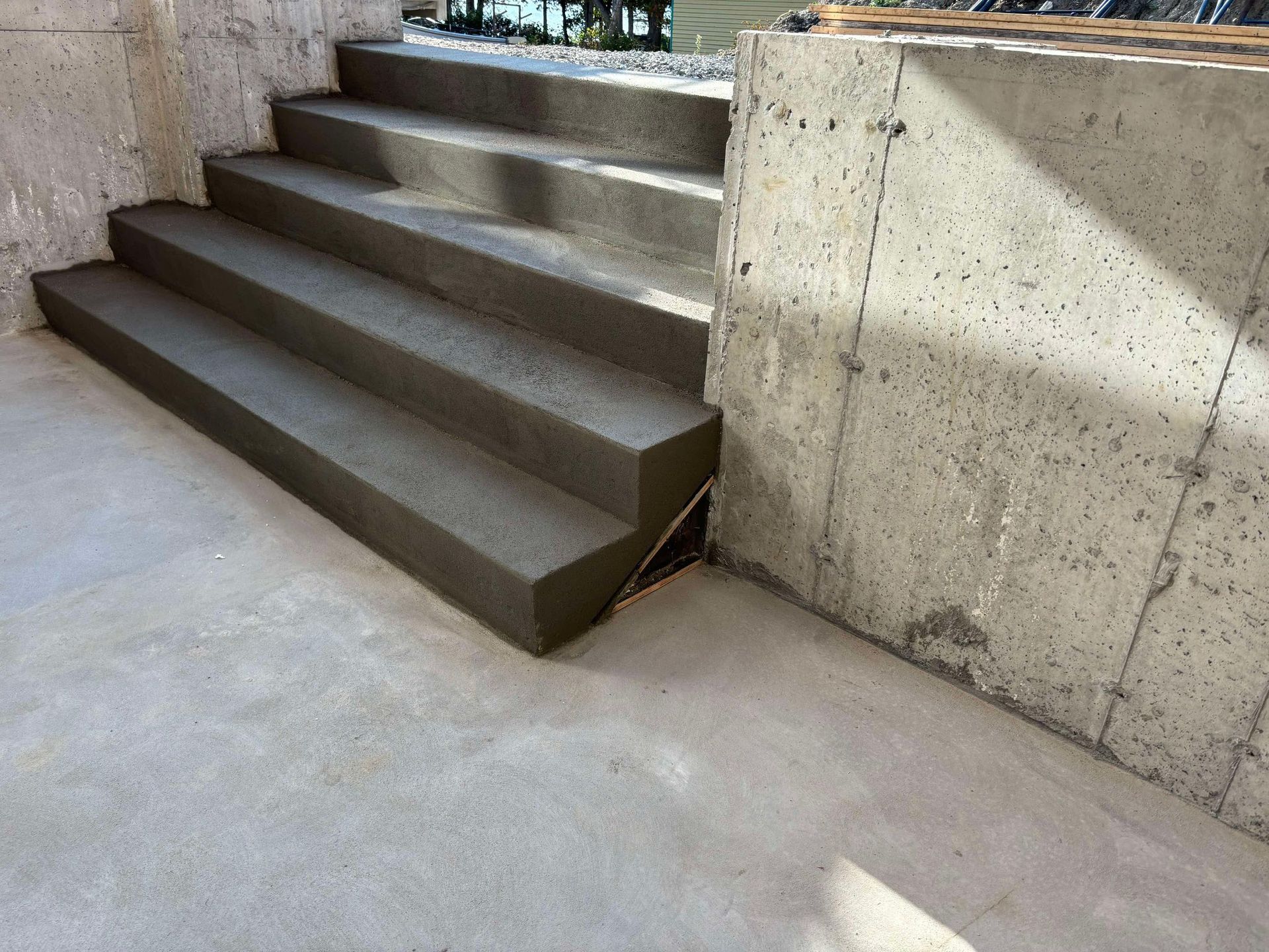 Escaliers extérieurs en béton menant à l'étage, posés contre des murs en béton.