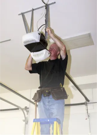 A man on a ladder working on a garage door opener