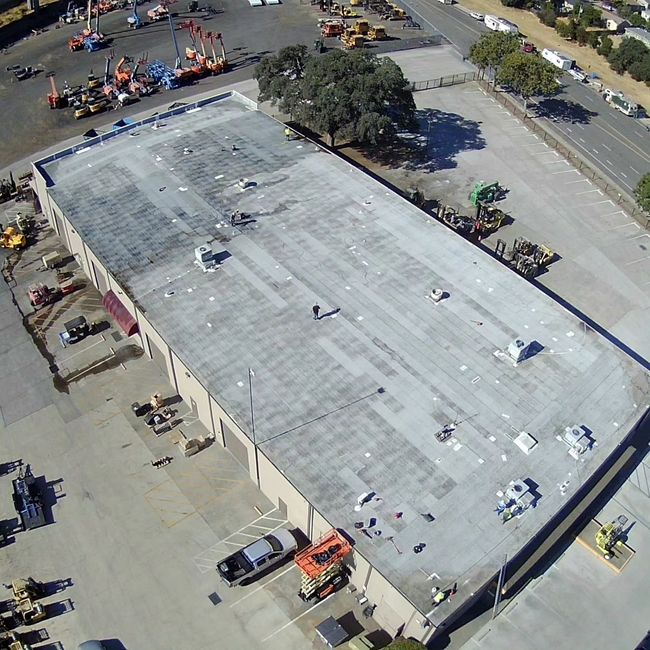 an aerial view of a large building with trucks parked on the roof