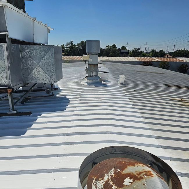 a white roof with a rusty pipe on it