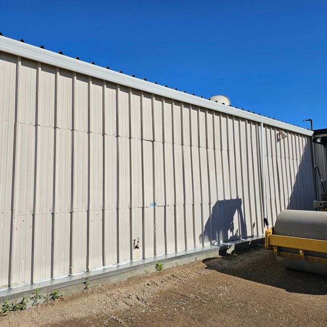 a large white building with a yellow roller in front of it