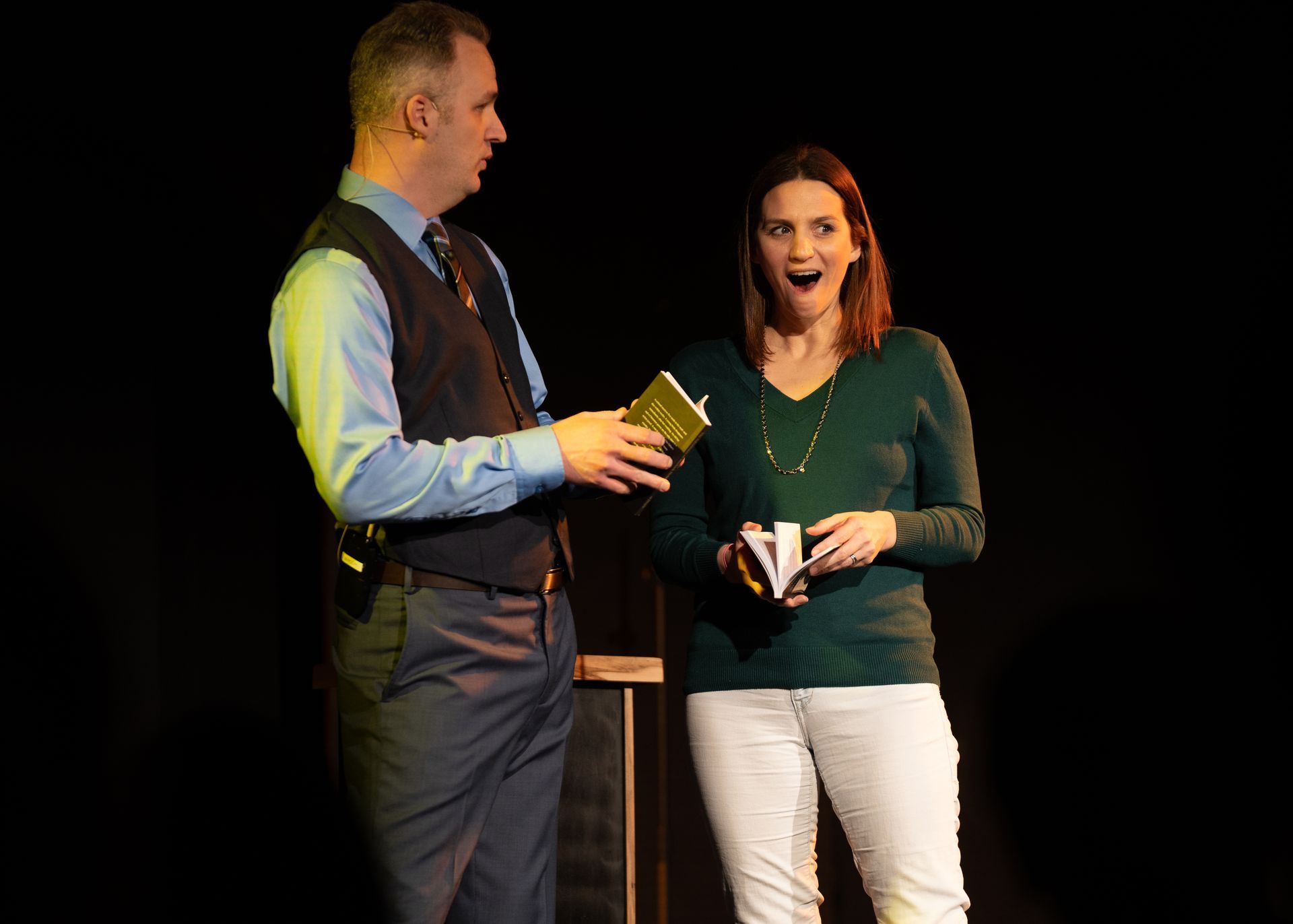 A man and a woman are standing next to each other on a stage.