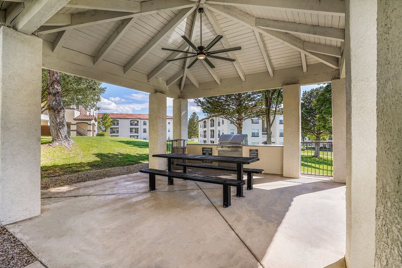 Covered pavilion with a picnic table and grill in a residential apartment community.