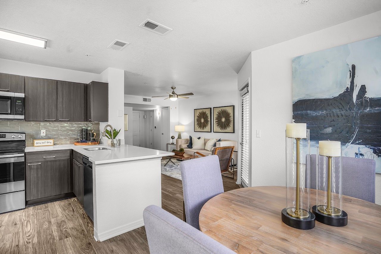 Open-concept kitchen with island, dining table, and living area in an apartment.