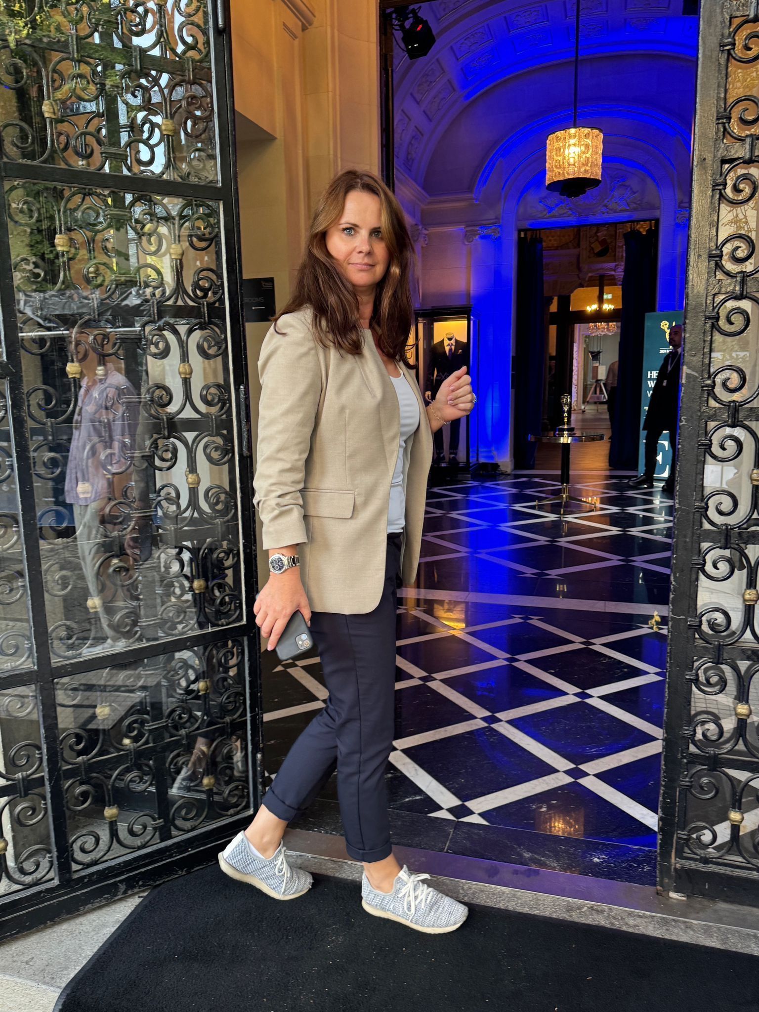 Eine Frau steht in einem Türrahmen, hinter ihr ein blaues Licht