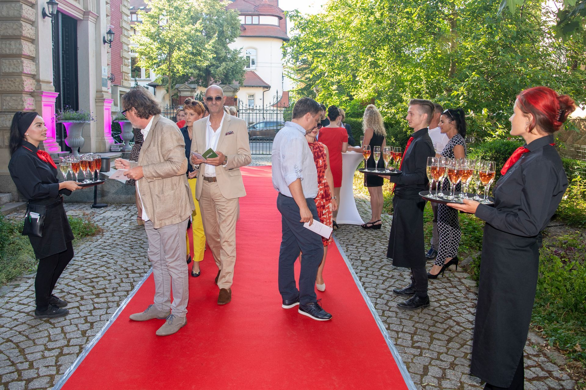 Eine Gruppe von Menschen steht auf einem roten Teppich