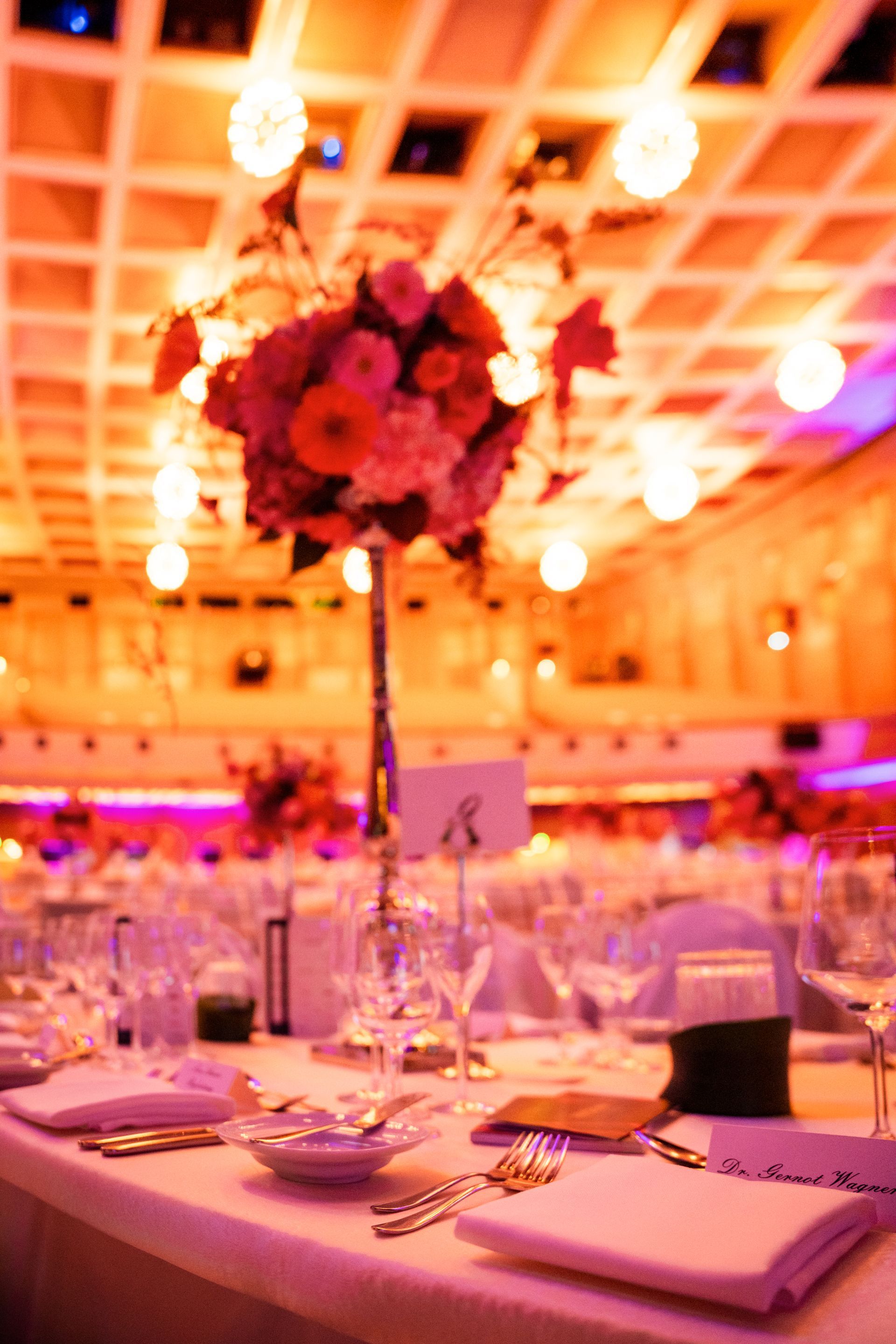 Ein Tisch mit einer Vase mit rosa Blumen darauf