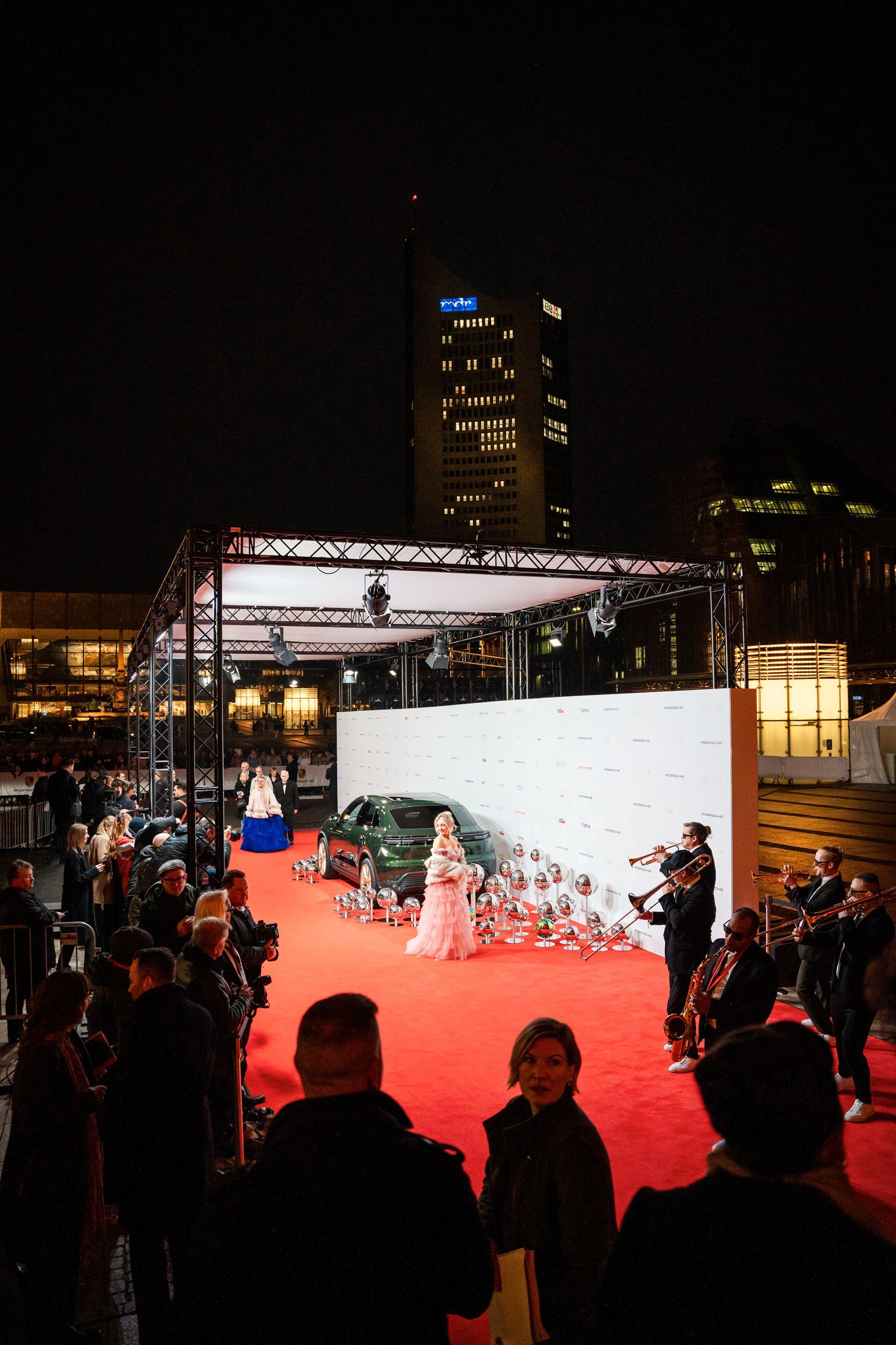 Eine Frau in einem weißen Kleid läuft über einen roten Teppich