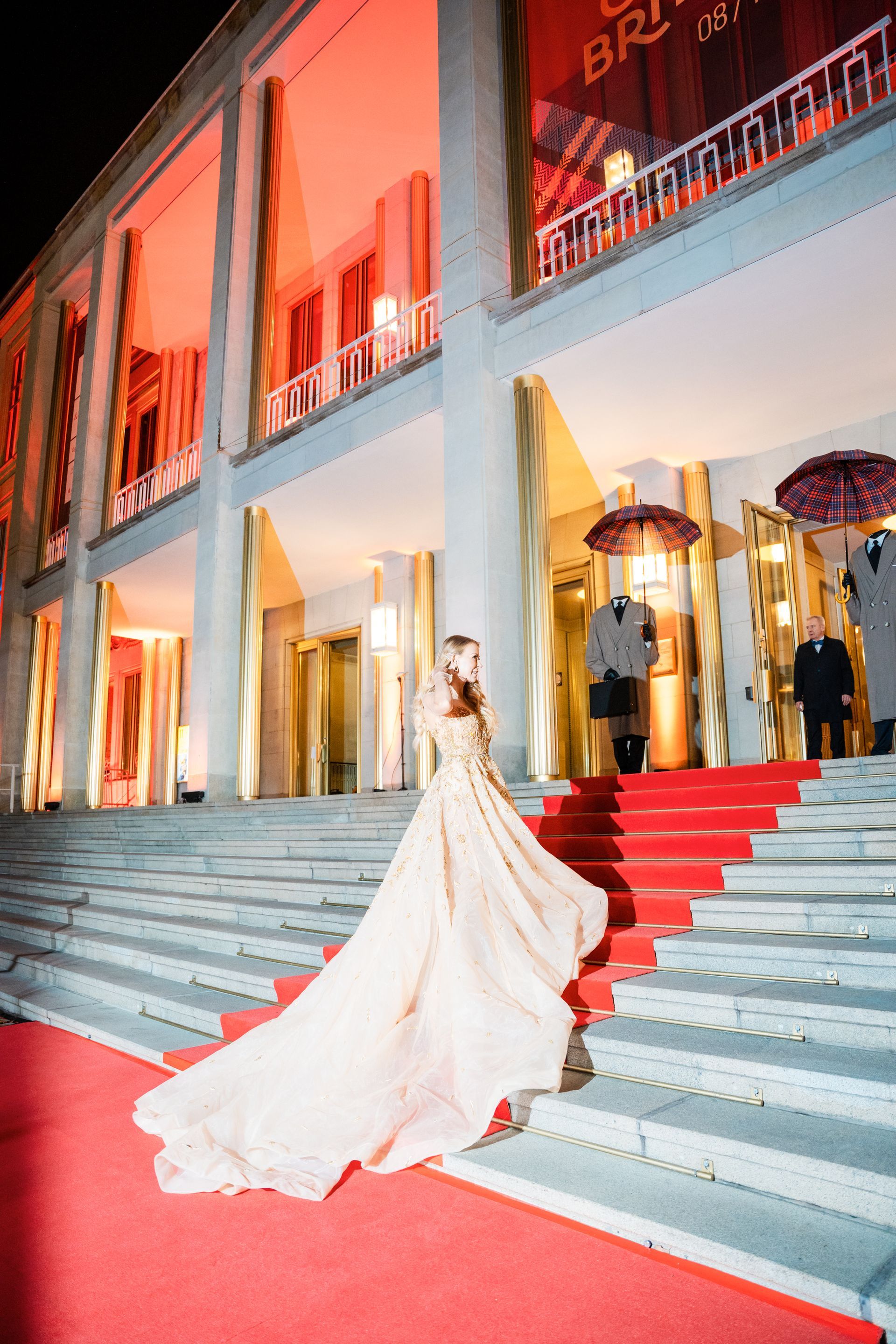 Eine Frau in einem langen Kleid geht eine rote Treppe hinunter