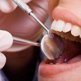 a close up of a person getting their teeth examined by a dentist .