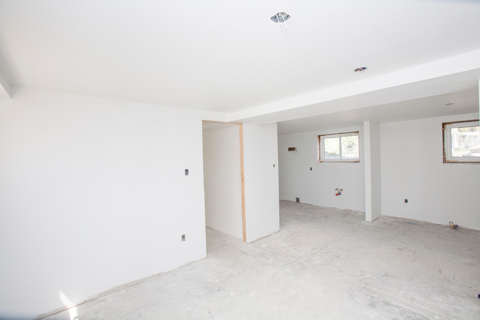 An empty room with white walls and a carpeted floor.