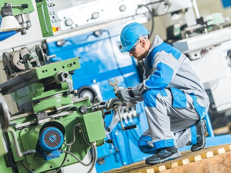 Lathe machine cutting metal, spraying coolant, generating metal shavings.