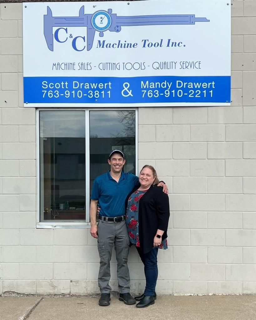 Couple standing in front of C & C Machine Tool Inc. sign. Building exterior.