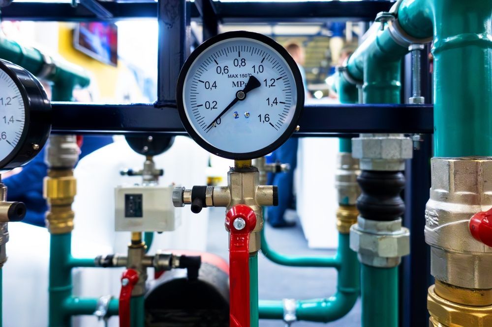 Pressure gauge on a network of green pipes, showing 1.0 MPa, with red and brass valves.