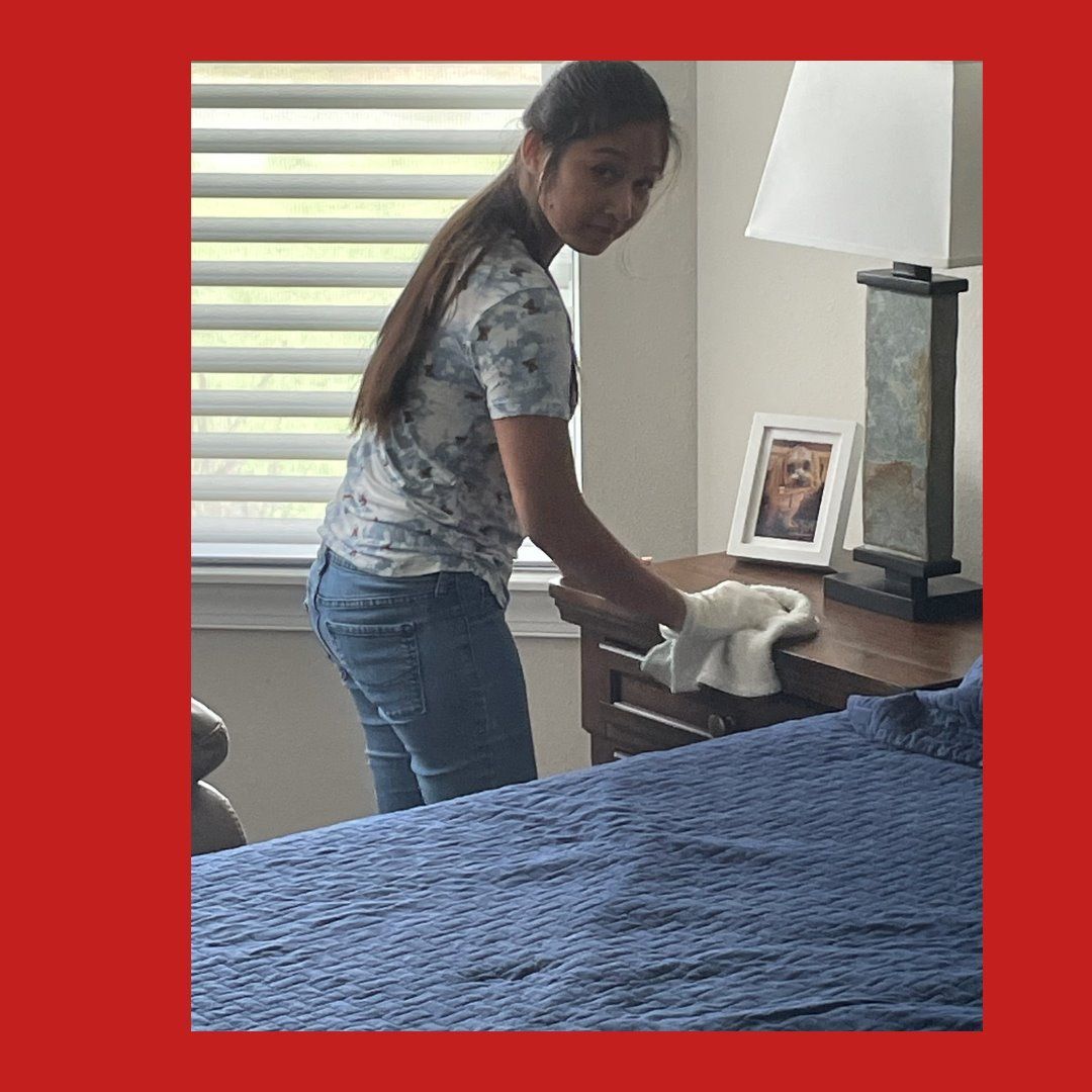 Trinity HouseKeepers staff performing regular home cleaning and surface dusting in a bedroom