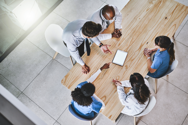 Equipe médica multidisciplinar discutindo o melhor tratamento para paciente
