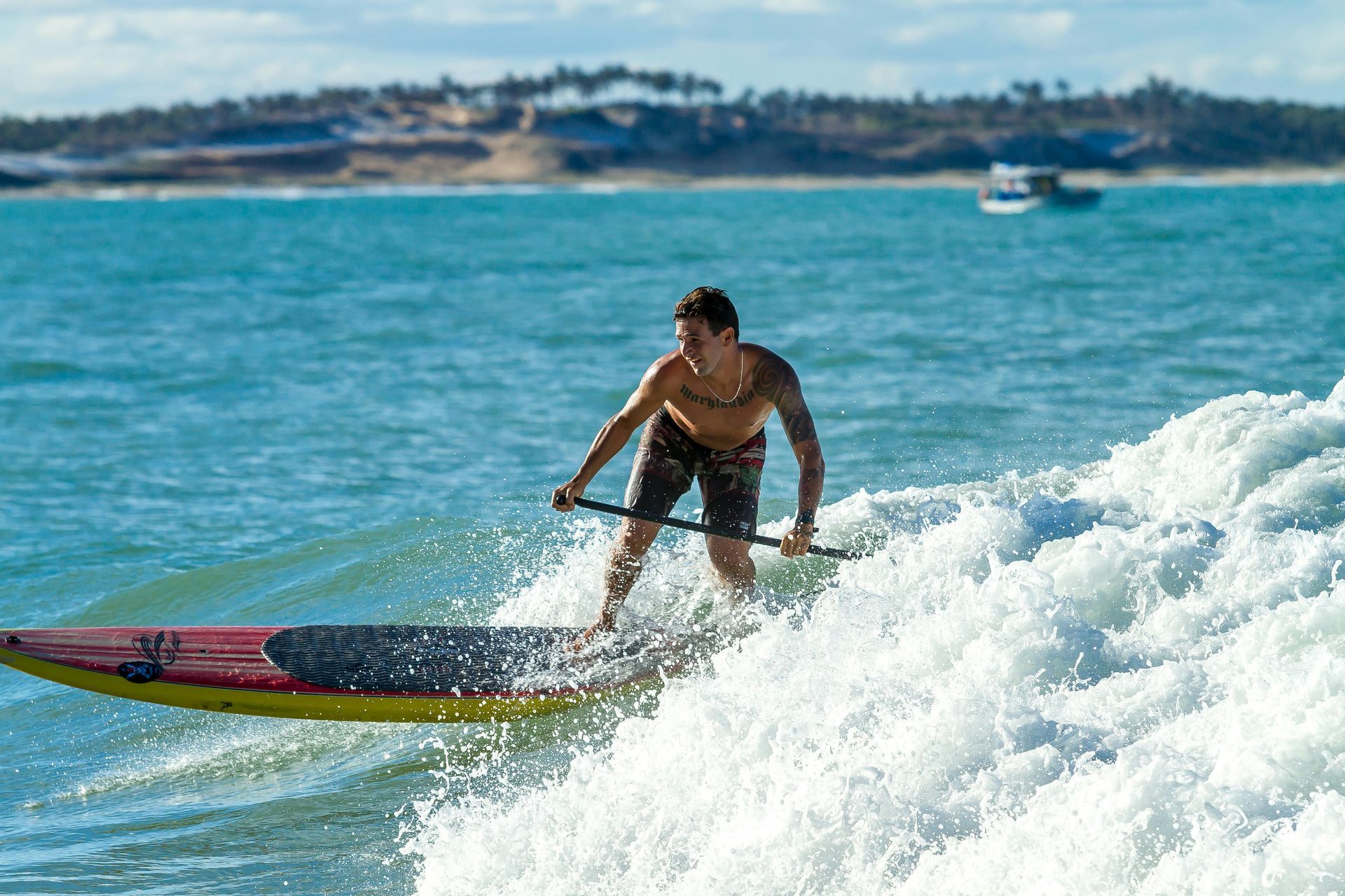 Un hombre está montando una ola en una tabla de surf en el océano.