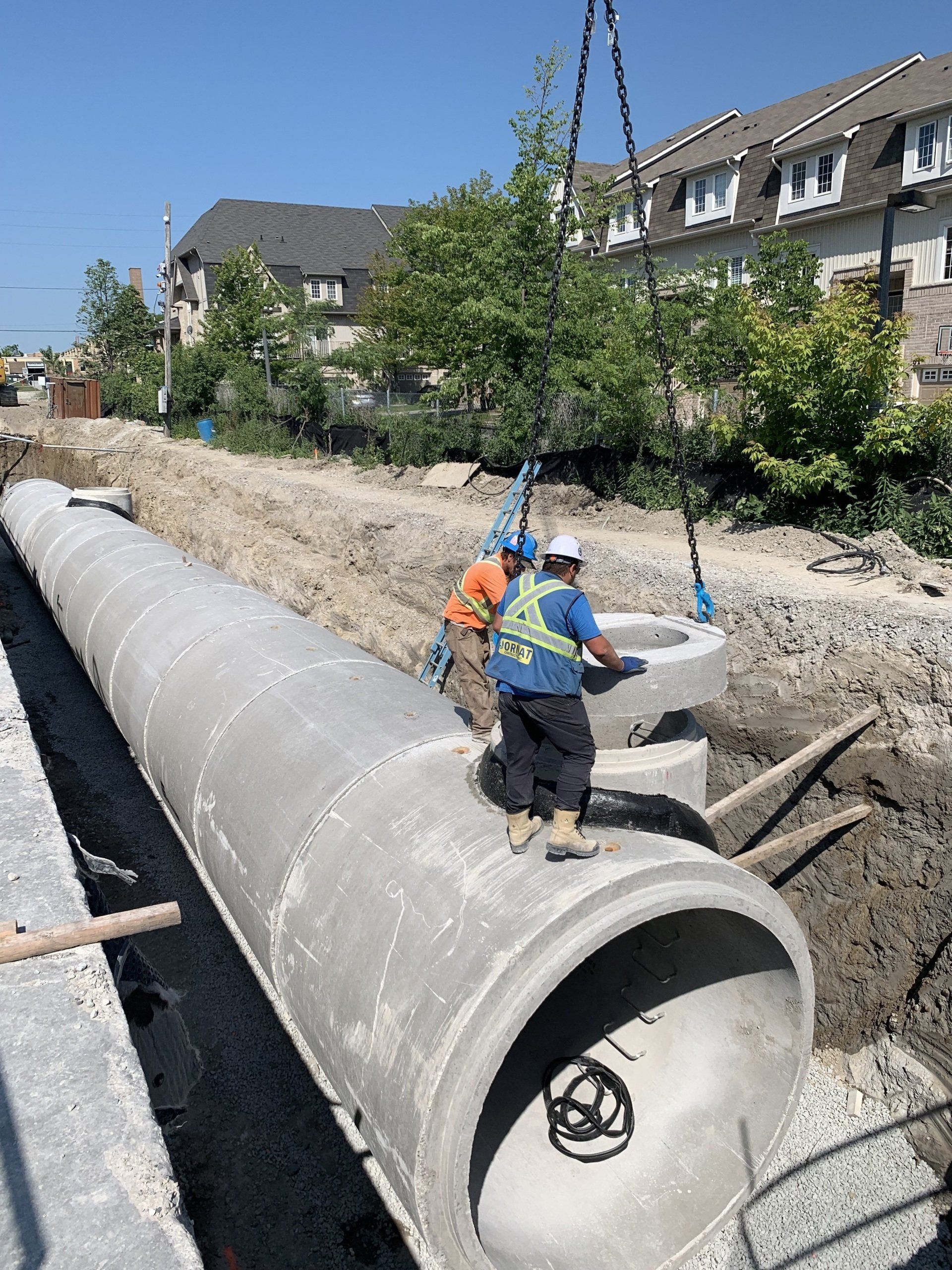 A group of construction workers are working on a large concrete pipe.