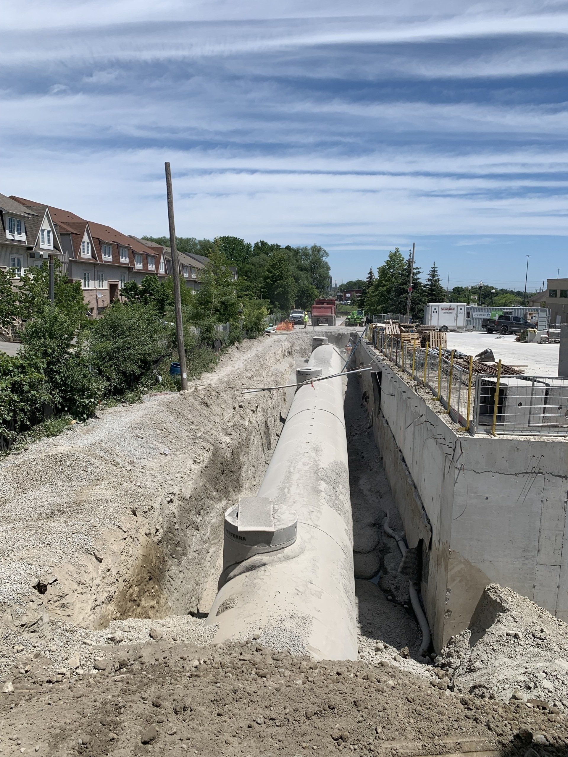 A concrete wall is being built next to a dirt road.