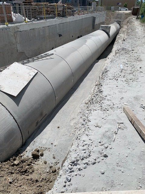 A large concrete pipe is laying on the ground