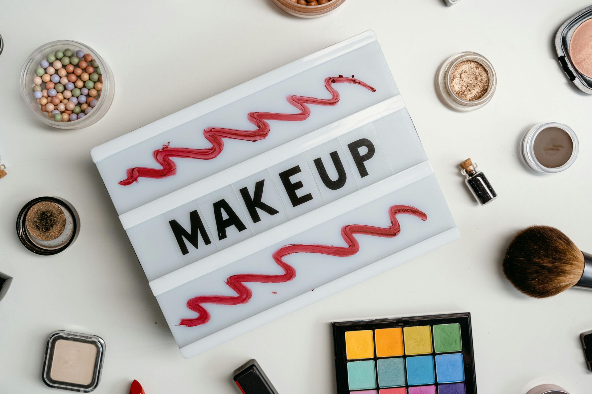 Makeup products arranged around a light-up sign with