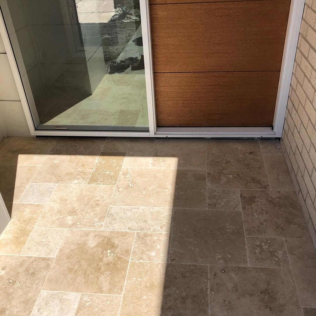 Tiled Floor With a Sliding Glass Door and a Wooden Panel — Seeto Tiling in Fingal Bay, NSW