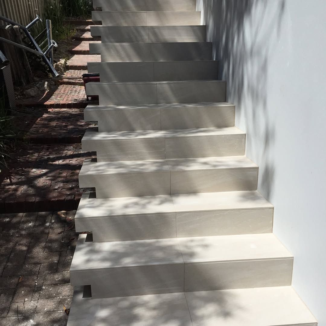 Concrete Stairs Leading Upwards, Set Against a White Wall With Unfinished Ground — Seeto Tiling in Fingal Bay, NSW