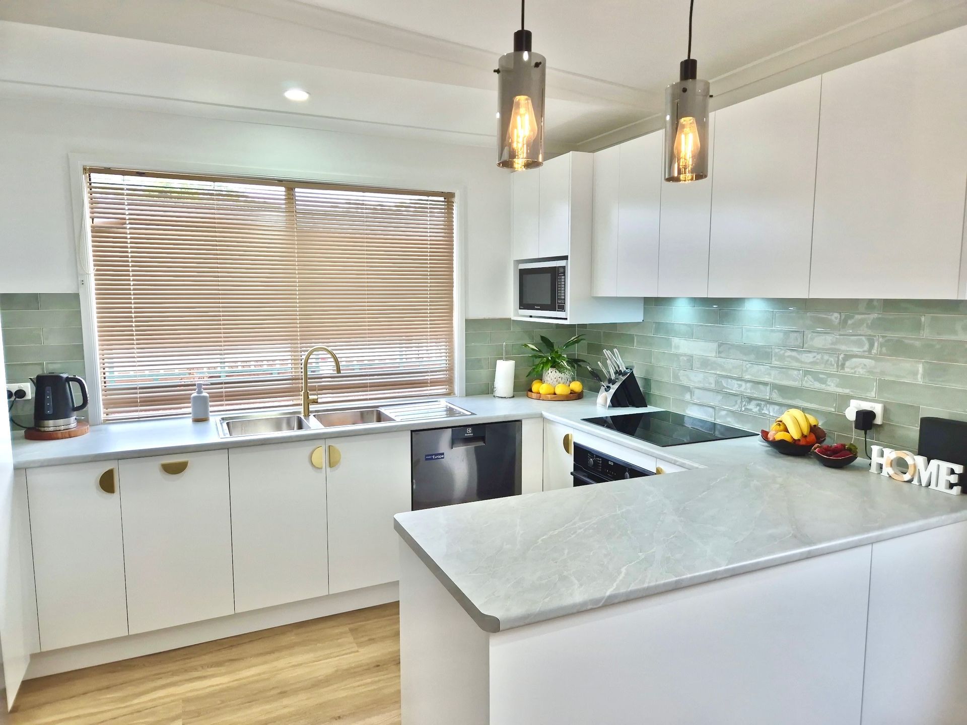 A small sized kitchen area with light coloured green tiles surrounding wall — Seeto Tiling in Fingal Bay, NSW