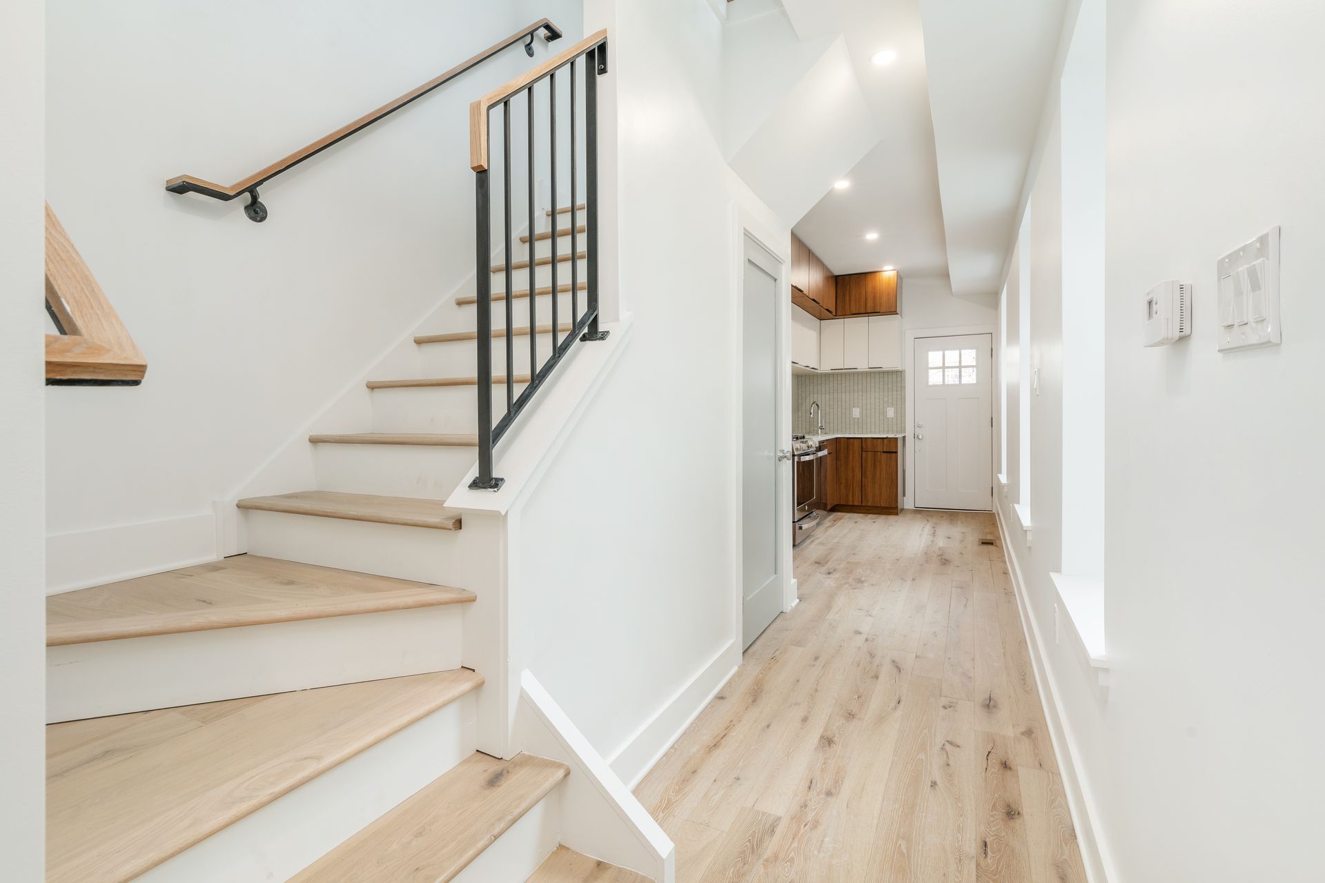 A hallway with stairs leading up to the second floor of a house