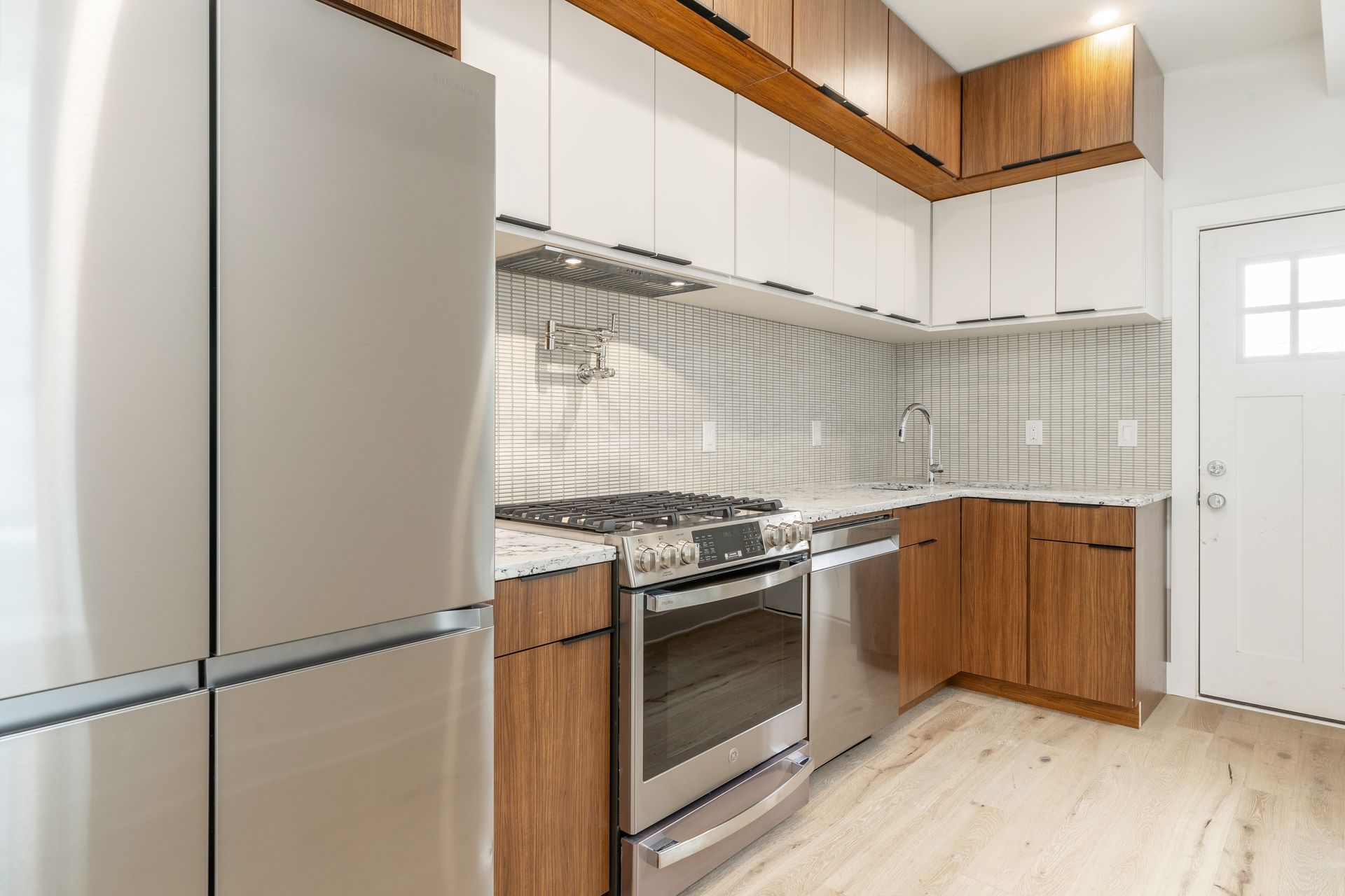 A kitchen with stainless steel appliances and wooden cabinets