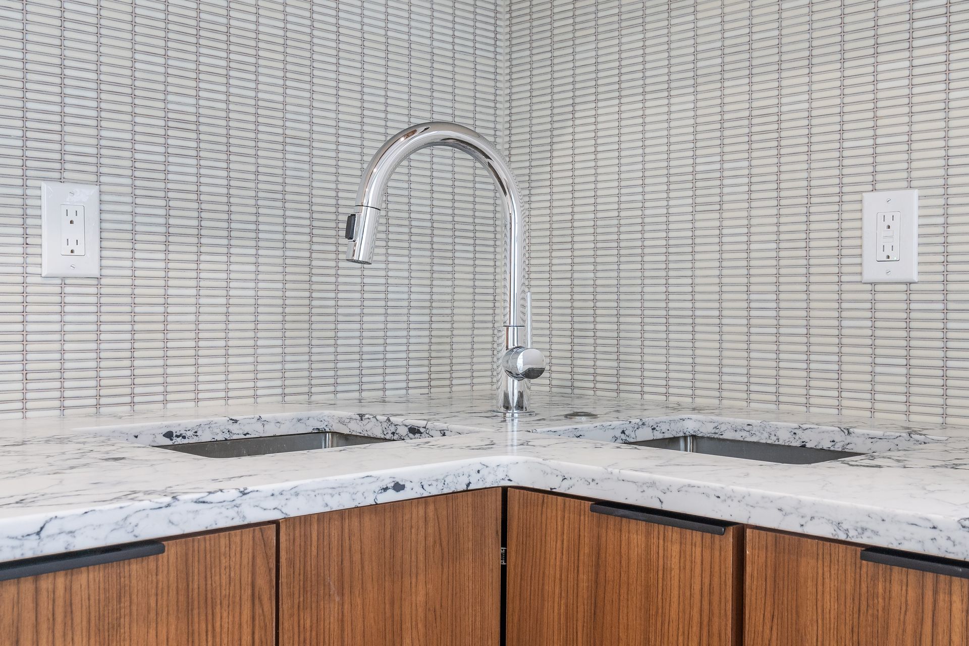 A kitchen with two sinks and a faucet.