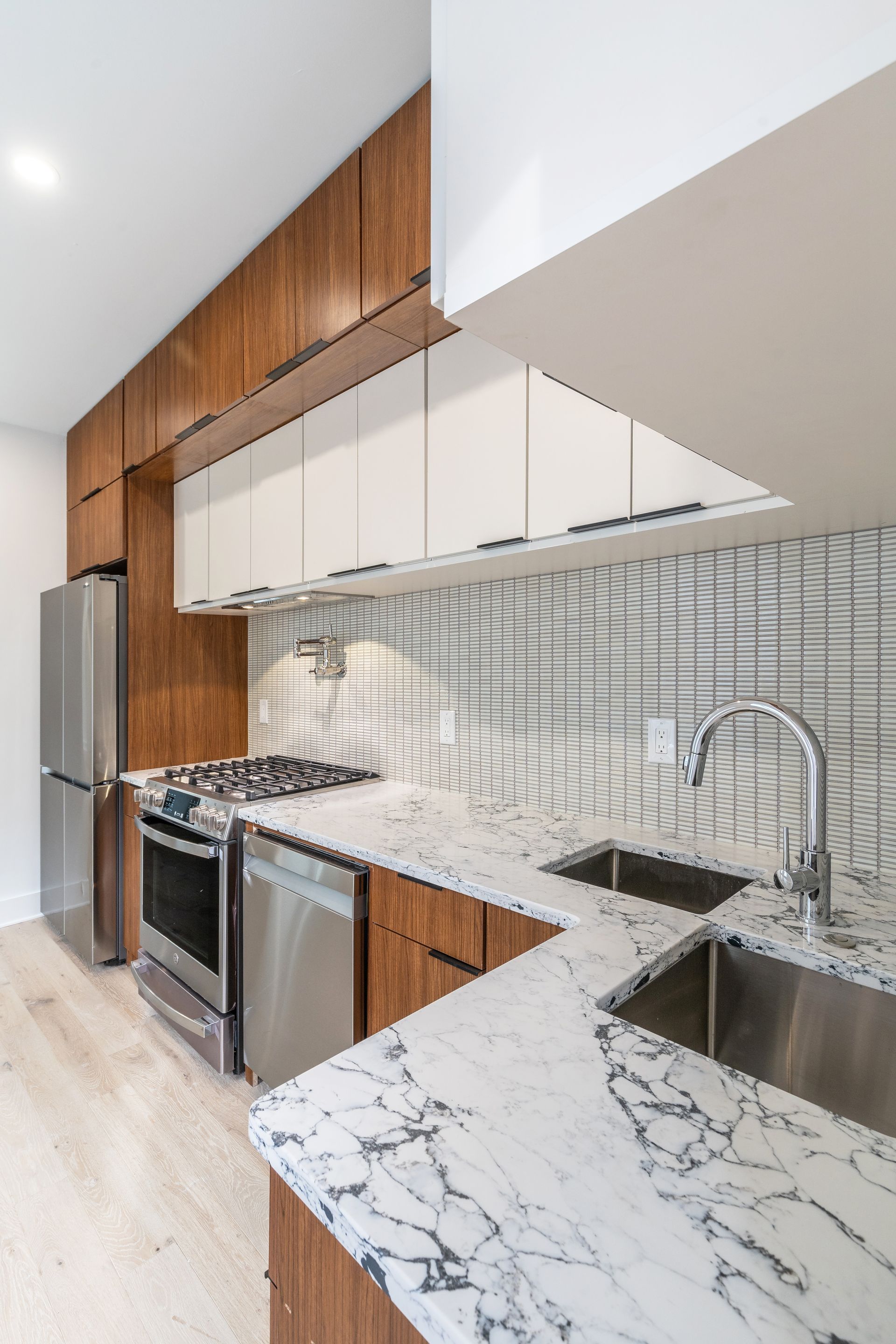 A kitchen with stainless steel appliances and marble counter tops