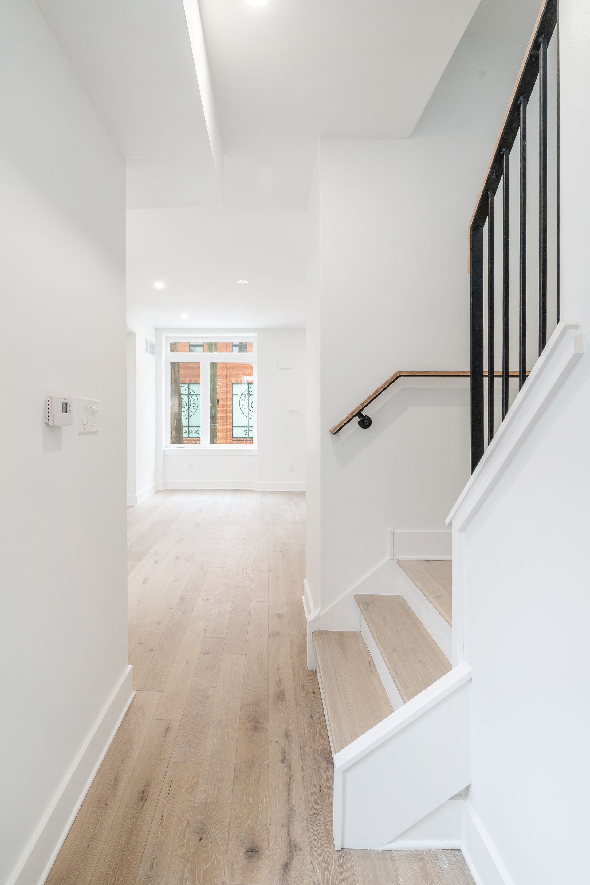 A hallway with stairs leading up to the second floor of a house.