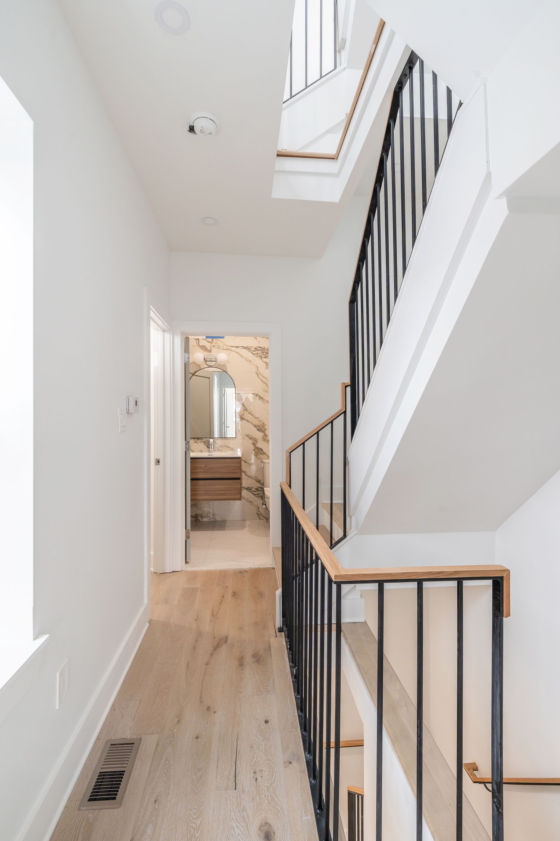A hallway with stairs leading up to the second floor of a house.