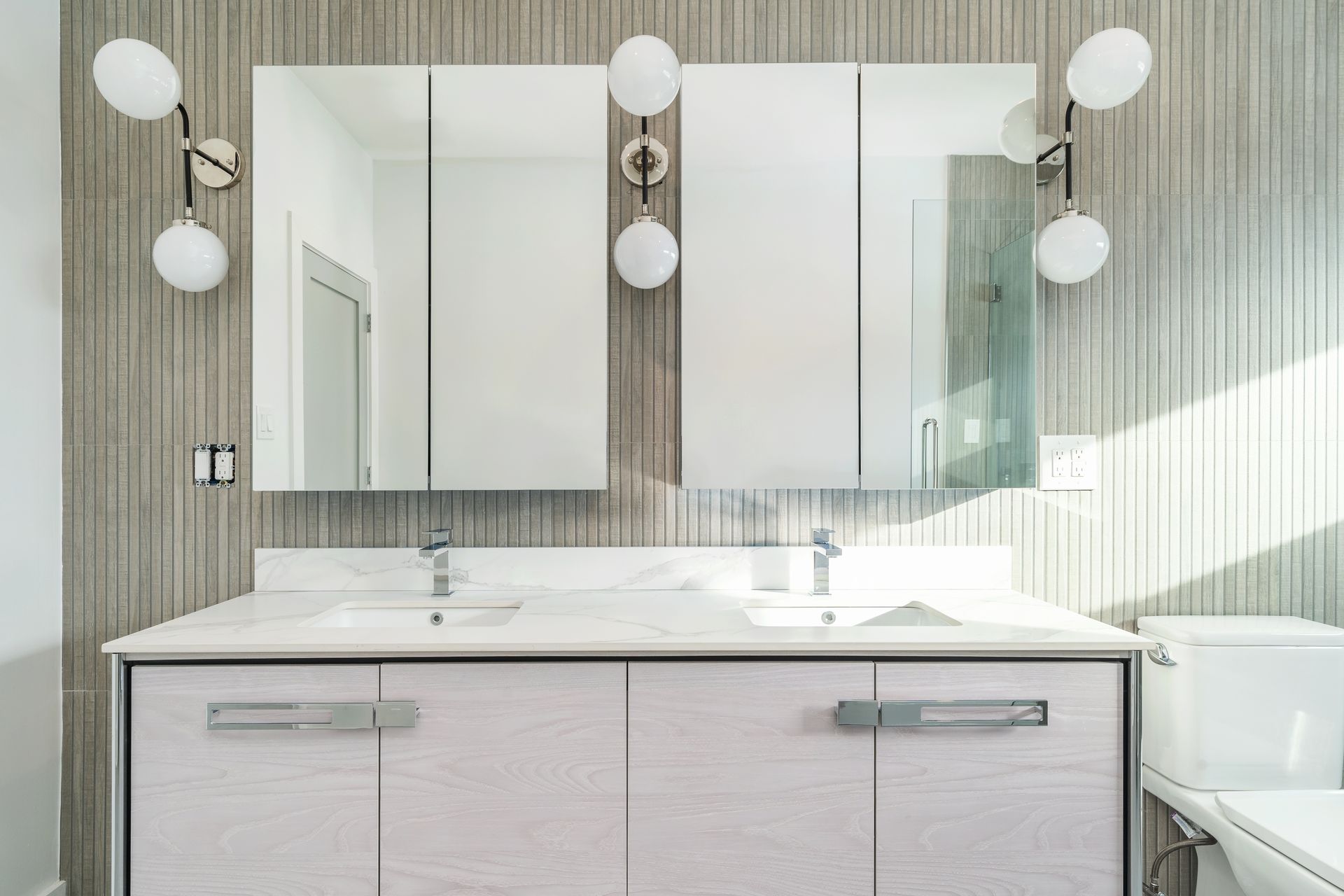 A bathroom with two sinks , a toilet , and a mirror.