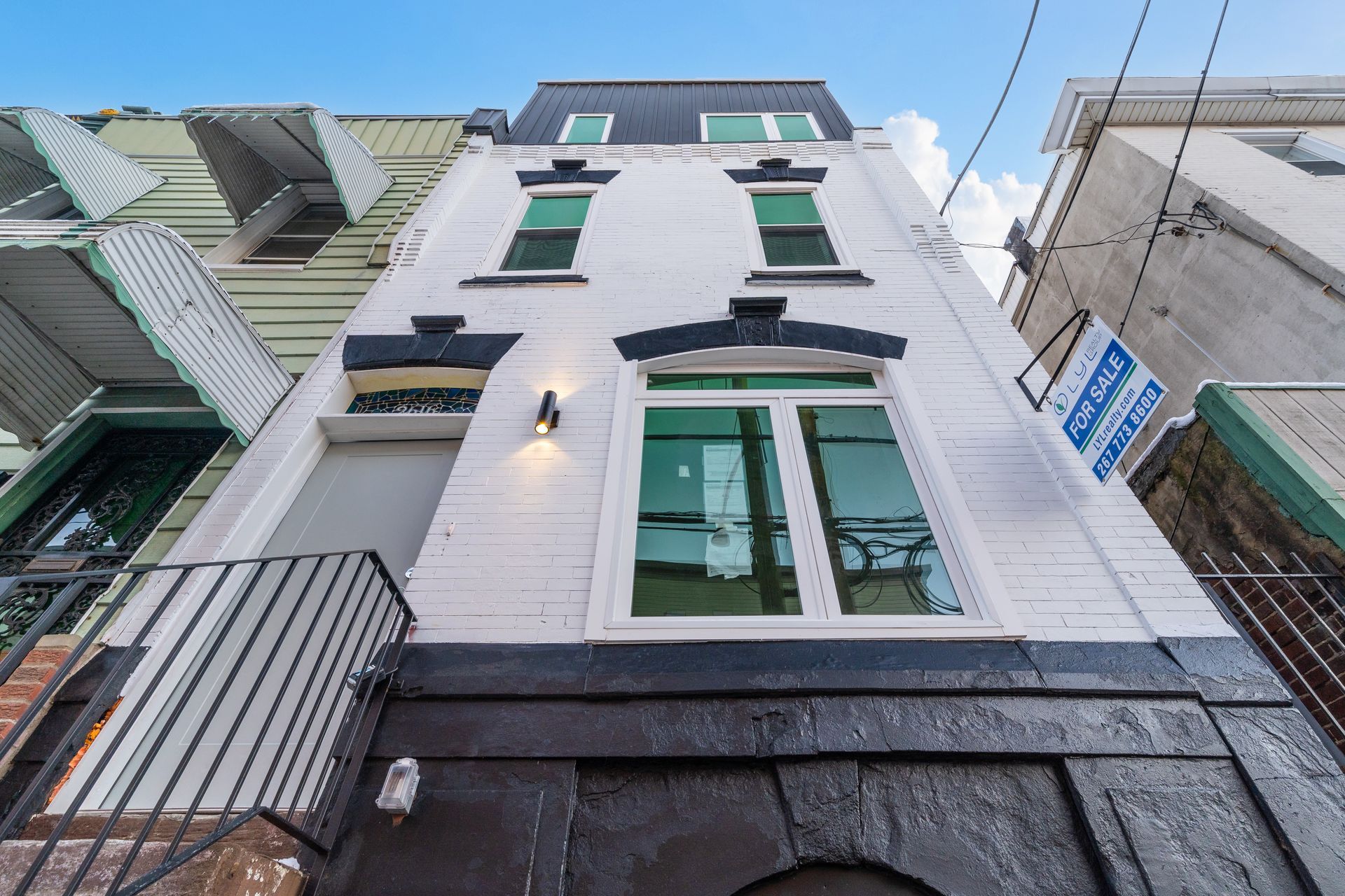 Looking up at a building with a for sale sign on the side