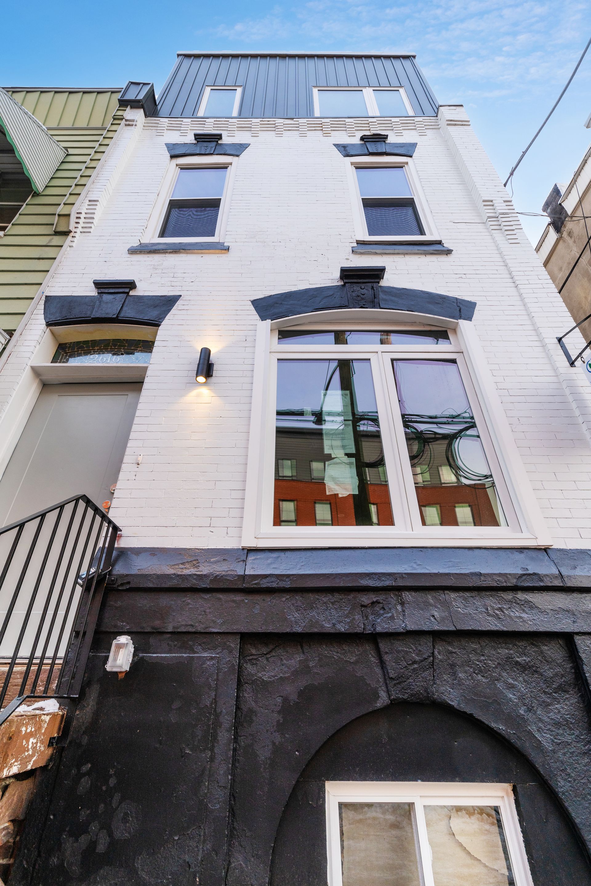 Looking up at a white building with black windows