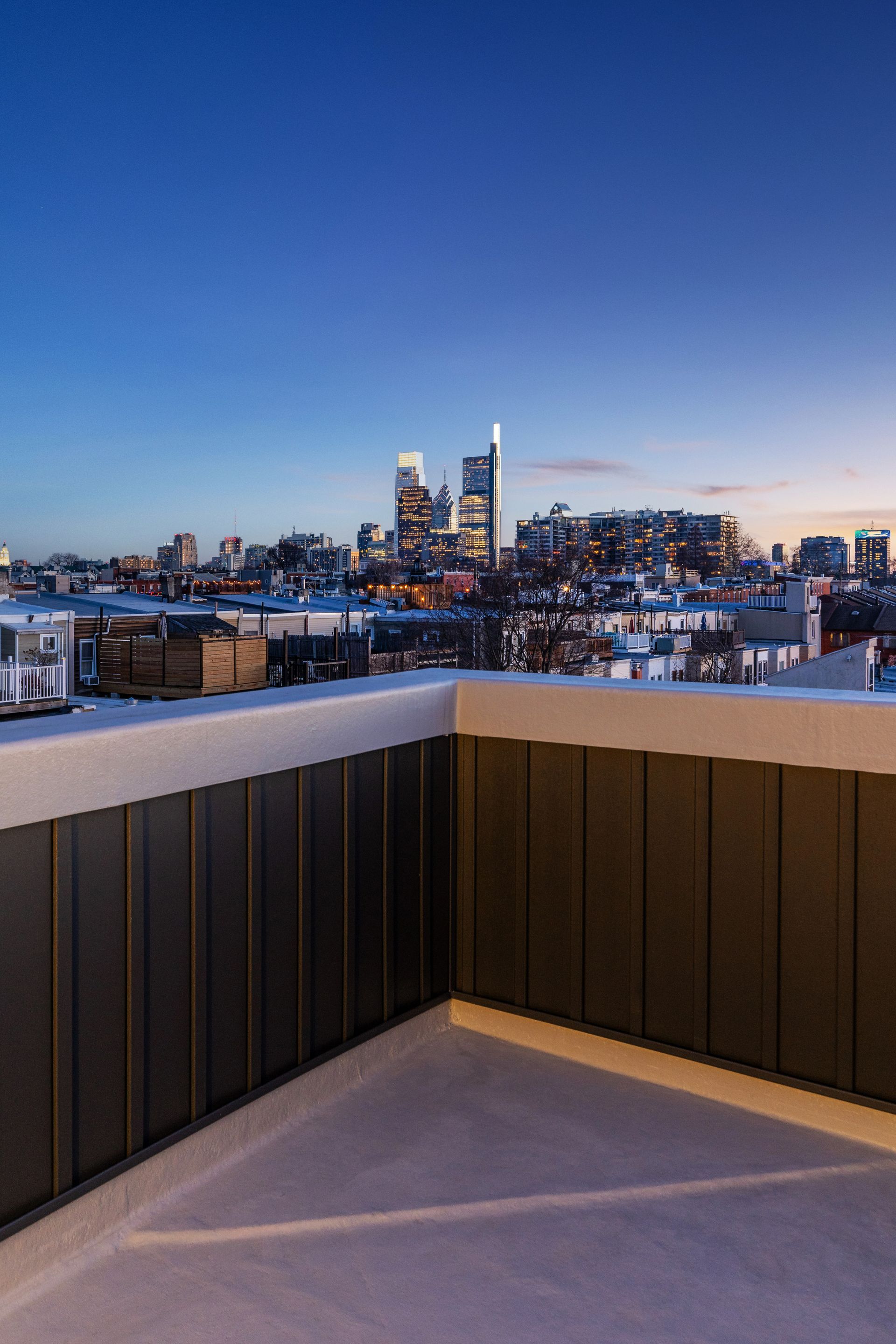 A balcony with a view of a city skyline at night.