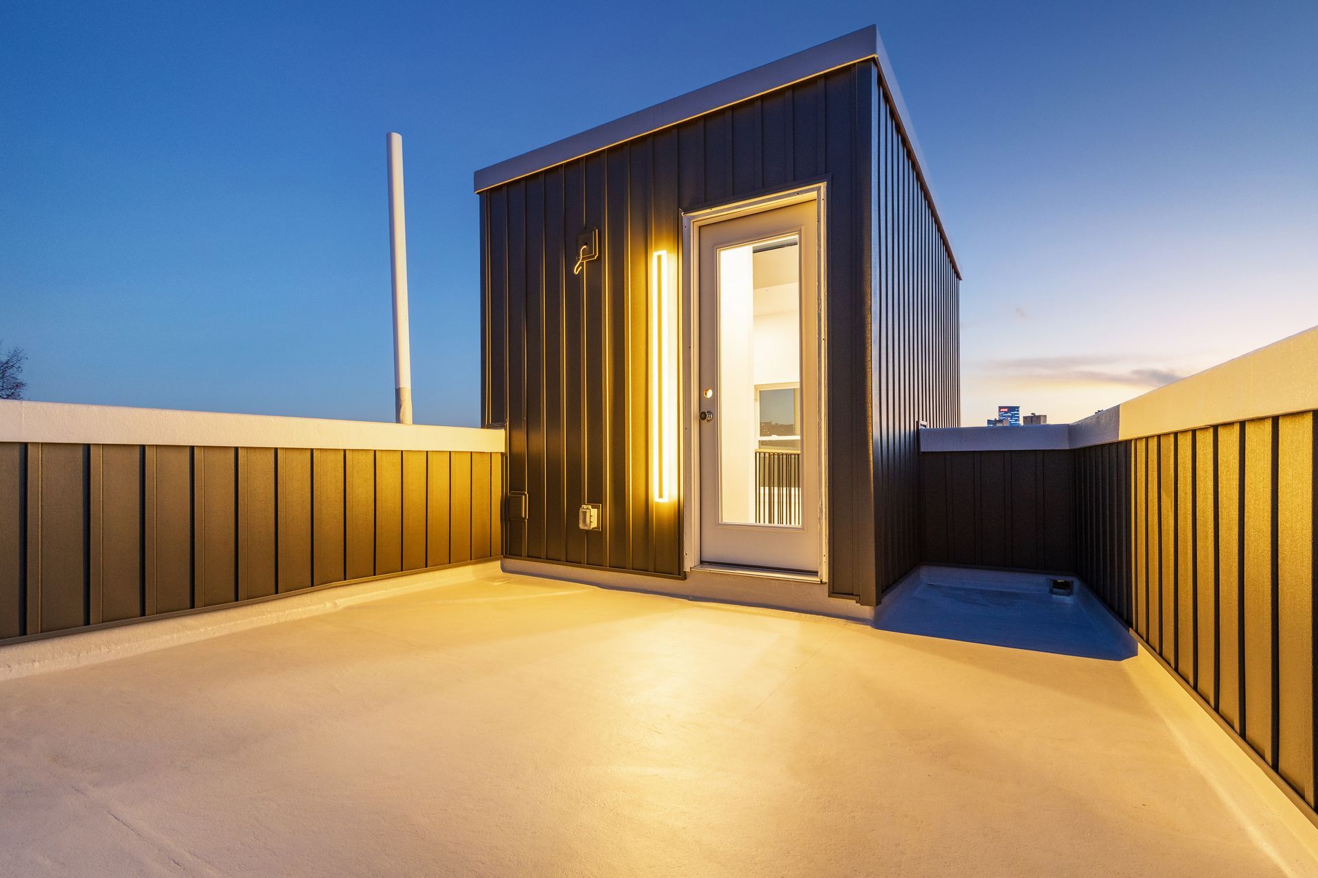 A rooftop deck with a small building in the background.