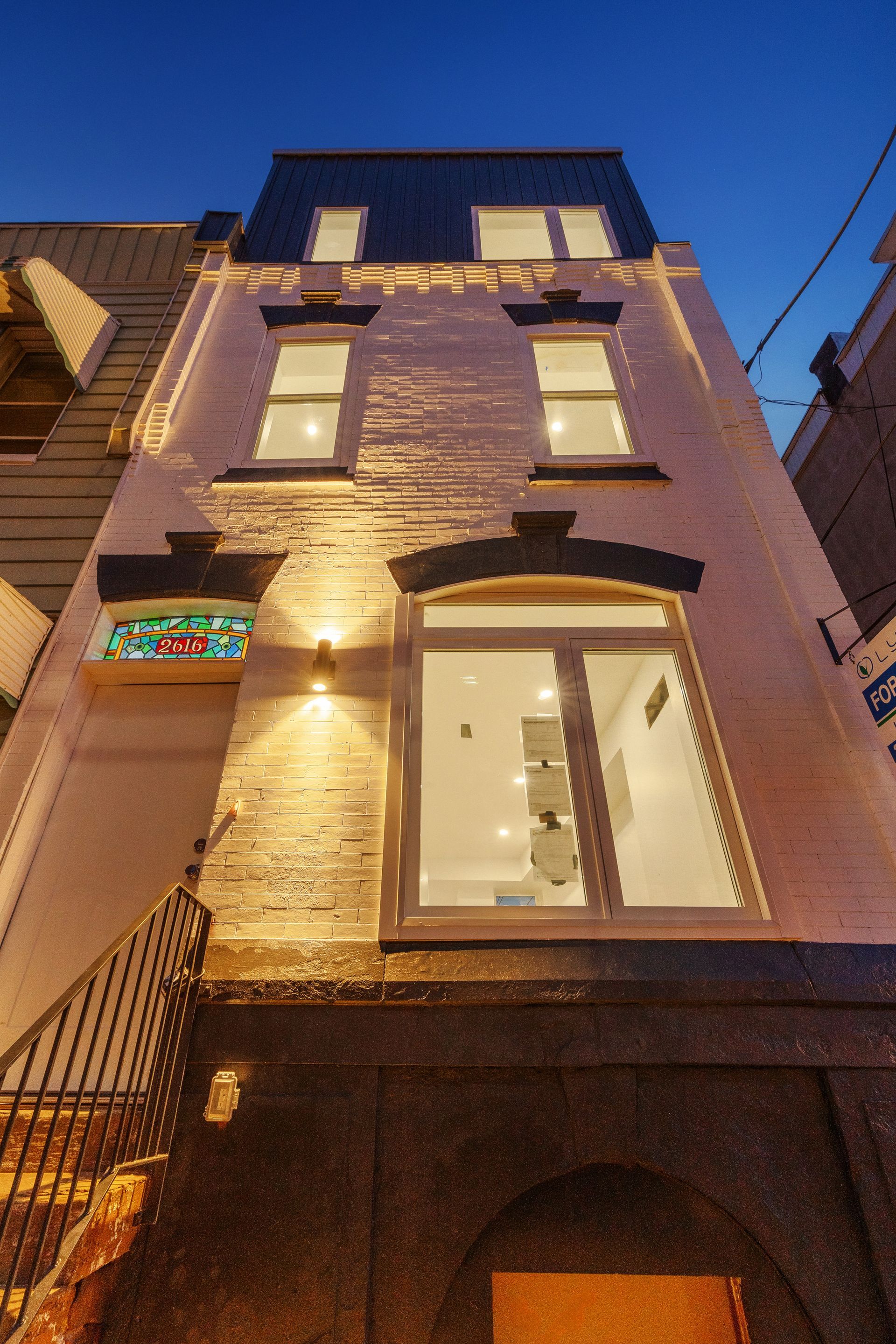 A tall building with a lot of windows is lit up at night.