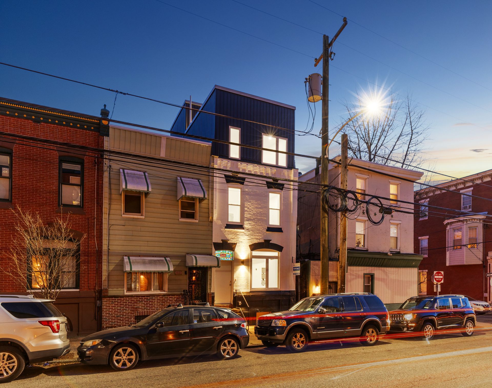 A row of cars are parked in front of a building