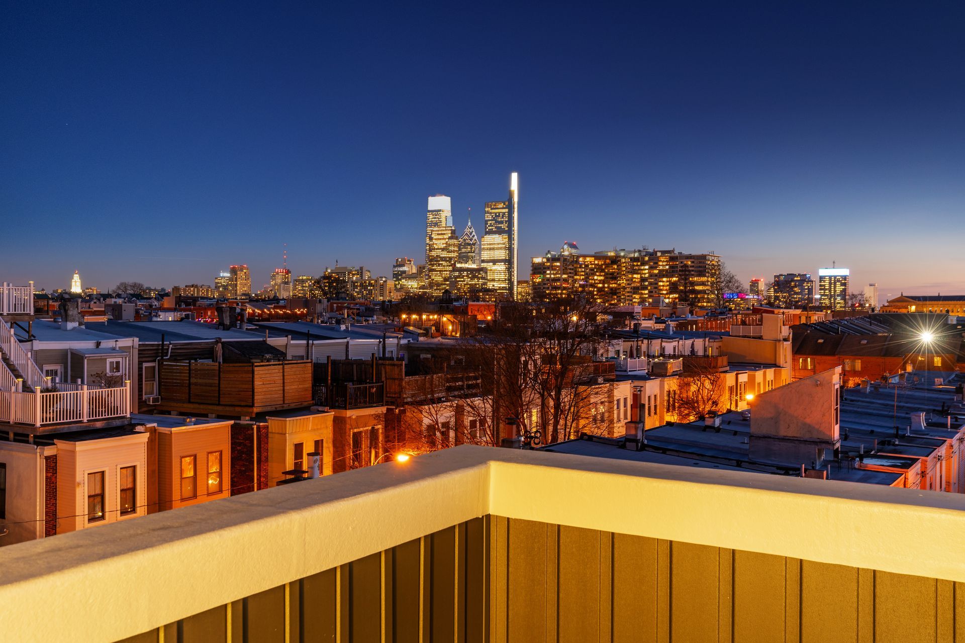 A view of a city skyline from a balcony at night.